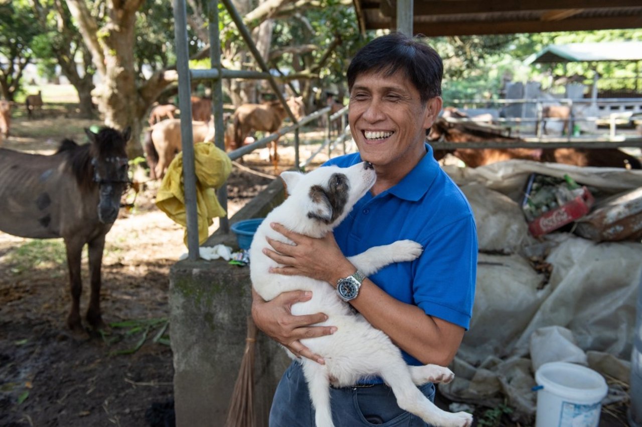 A man with a dog at an animal rescue shelter in the city of Lipa, Batangas