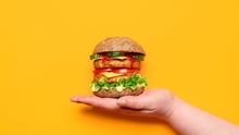 A hand holding up a veggie burger