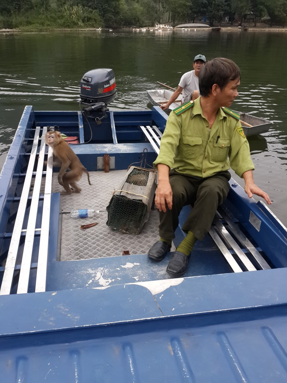 The rescue team in a boat with the two macaques