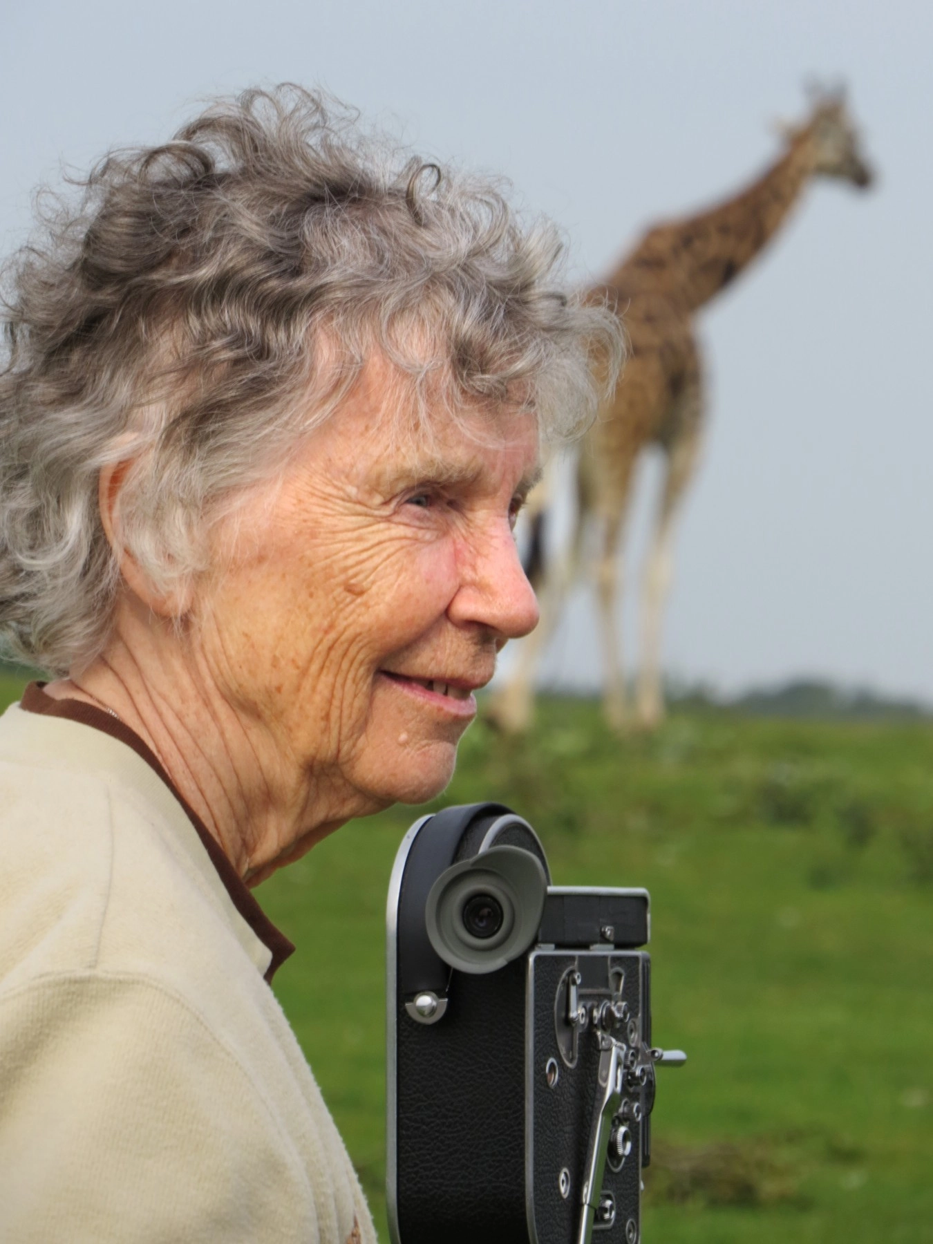 A portrait of Dr. Anne Innis Dagg with a giraffe in the background